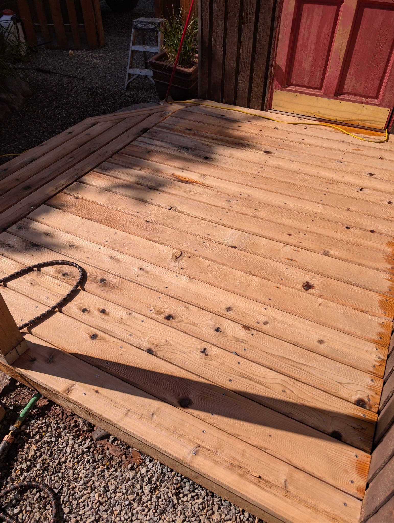 A cedar deck washed back to clean timber and sealed, with the grain and knots showing through