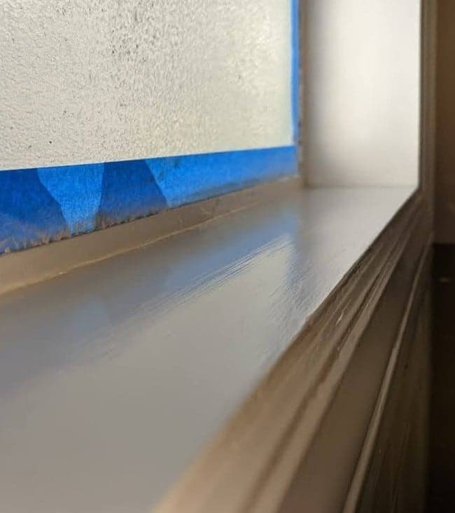 The same sill finished in white with masking tape still along the glass