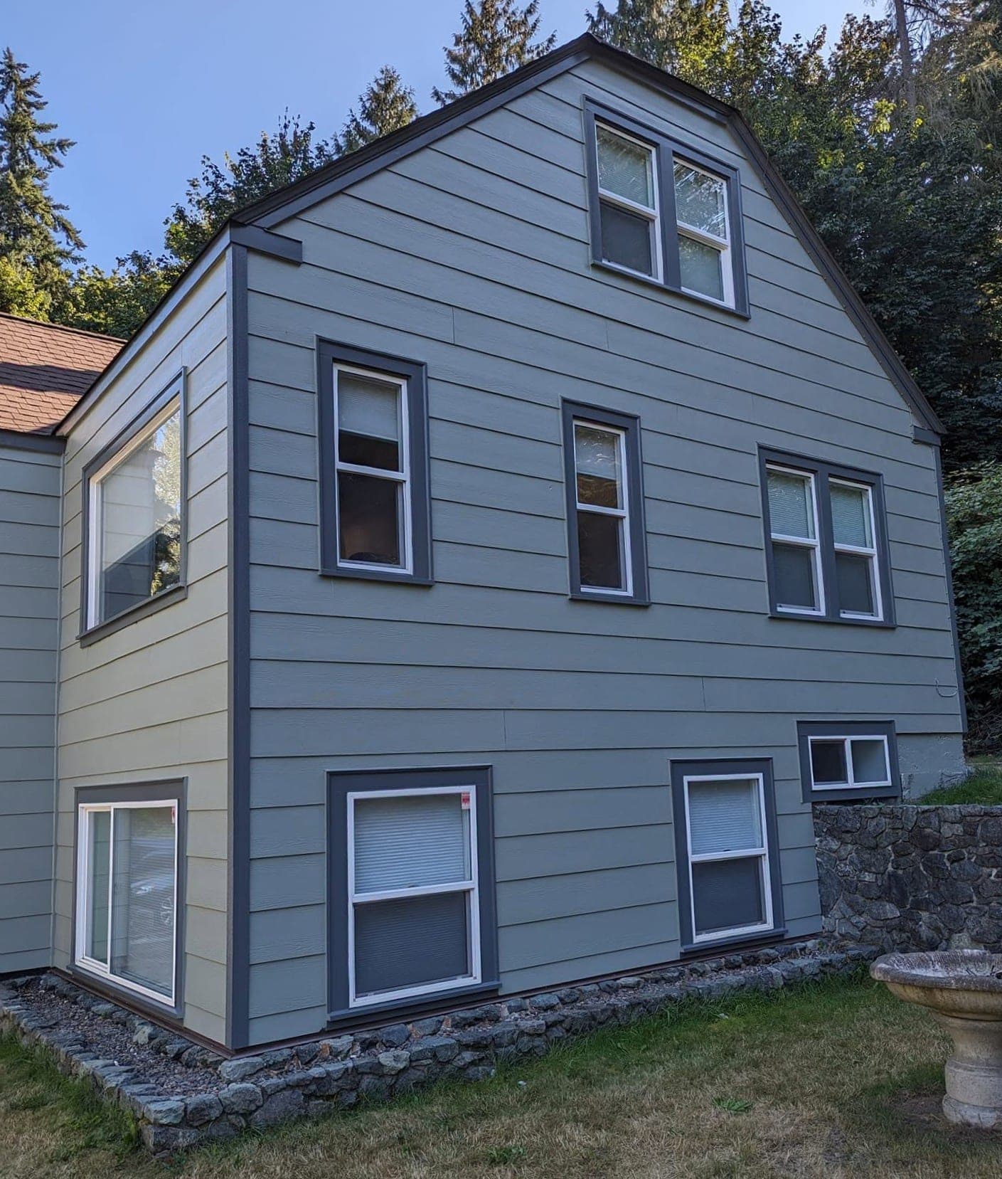 Crisp charcoal and white window trim and clean glass on a freshly repainted house
